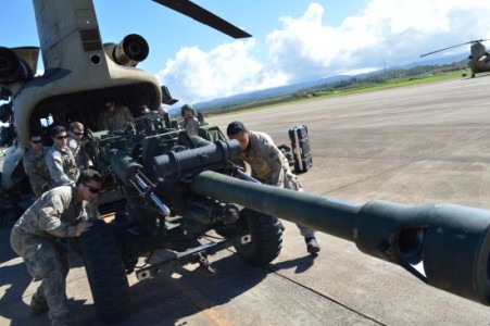 New Zealand and U.S. Soldiers offload an M119A3 105mm howitzer from a CH-47 helicopter at Wheeler Army Air Field